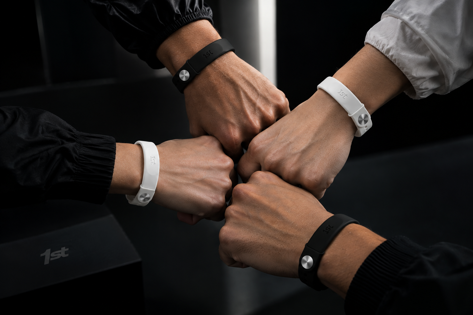 Four fists meeting in the center, each wearing a black or white 1st band